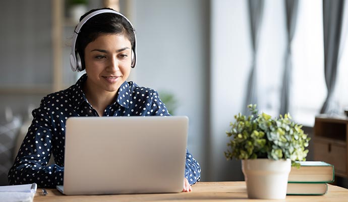 Woman using headphone at Laptop